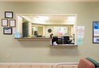 Patients sit in a bright community clinic waiting room before their appointments.