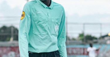 A match official reviewing a play on a pitch-side screen