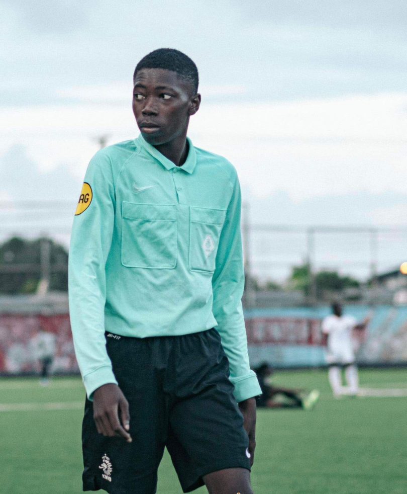 A match official reviewing a play on a pitch-side screen